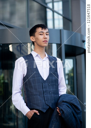 Oriental man in suit, business person, manager stands on city center background Oriental man in suit, business person, manager stands on city center background 121647518