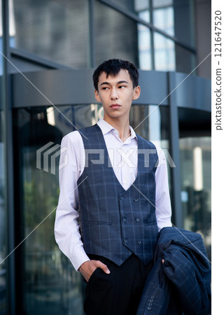 Oriental man in suit, business person, manager stands on city center background Oriental man in suit, business person, manager stands on city center background 121647520