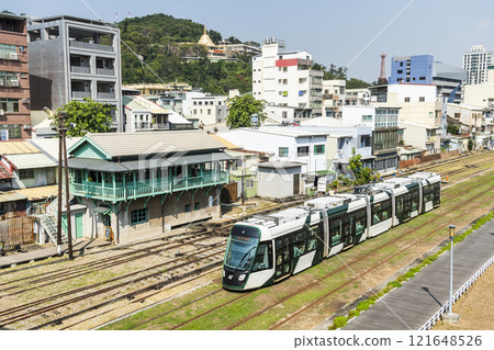 The circular light rail train drives past the former Kaohsiung Port Station North Signal Box, Taiwan. 121648526