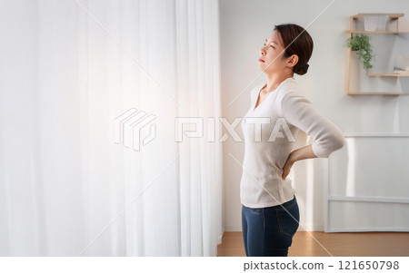 一名30至40多歲的女性，患有腰痛。 121650798