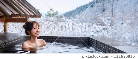 一位年輕女子在雪景中享受露天浴池。溫泉。觀雪浴。 121650930