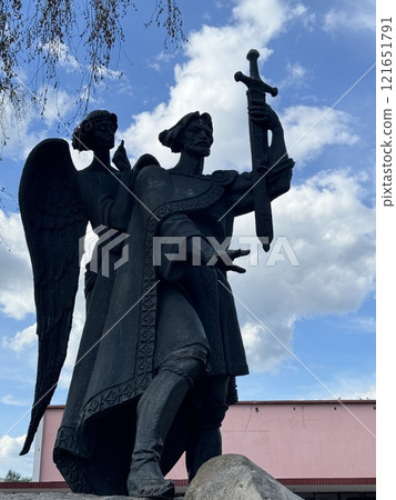 Majestic Statue of Warrior and Angel Under Cloudy Sky Majestic Statue of Warrior and Angel Under Cloudy Sky 121651791