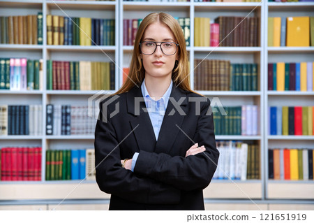 Portrait of confident teenage girl student, inside educational building 121651919
