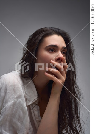 Sensual woman in white shirt and fishnet tights touching face 121652056