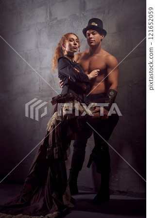 Naked loving couple holding each other tightly in dark studio Naked loving couple holding each other tightly in dark studio 121652059