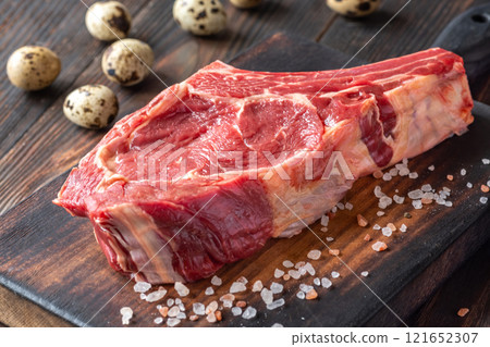 Raw Cowboy Steak with Marbling on Wooden Board, Ready to Cook Raw Cowboy Steak with Marbling on Wooden Board, Ready to Cook 121652307