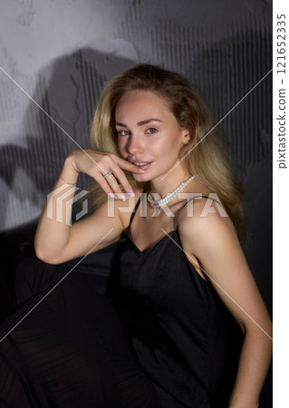 An Elegant Woman in a Beautiful Black Dress Posing Elegantly with Grace and Charm 121652335