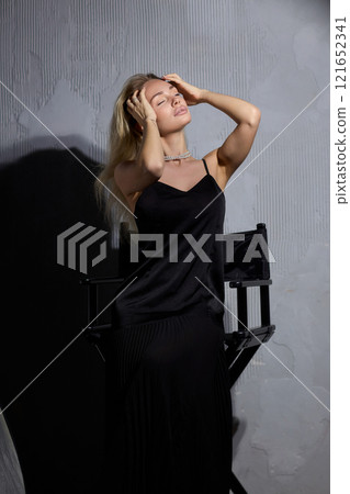 An Elegant Woman in a Beautiful Black Dress Posing Elegantly with Grace and Charm 121652341