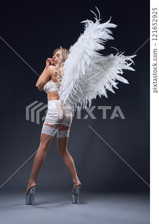 Saxy woman in angel costume during role-playing game 121652925