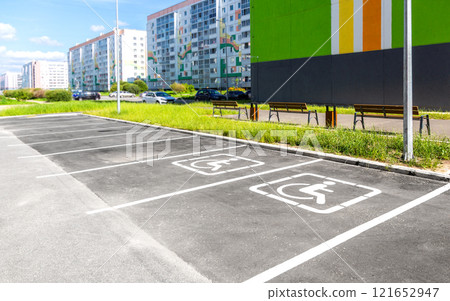 Parking places with handicapped or disabled signs and marking lines on asphalt at the yard Parking places with handicapped or disabled signs and marking lines on asphalt at the yard 121652947