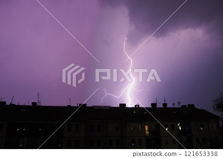 Multiple flashes of light and lightning. Lightning electrical spark discharge in atmosphere that occurs during thunderstorm manifested by bright flash of light accompanying thunder. Roof of the house. Multiple flashes of light and lightning. Lightning electrical spark discharge in atmosphere that occurs during thunderstorm manifested by bright flash of light accompanying thunder. Roof of the house. 121653338