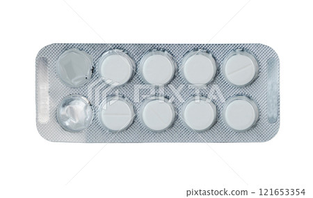 Blister pack containing round white pills displayed on a flat surface 121653354