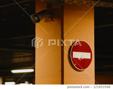 Loudspeaker and prohibition sign on a column in an underground parking lot. Red round sign with a horizontal white stripe. No entry sign on the oncoming traffic lane. December 27, 2024 - Pula, Croatia 121653506
