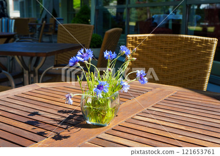Posy of Cornflowers on a Table in a Street Cafe in Palanga, Lithuania. Posy of Cornflowers on a Table in a Street Cafe in Palanga, Lithuania. 121653761