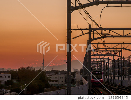 The Shin-Keisei Line running with Mt. Fuji and Tokyo Skytree in the background at dusk 121654545