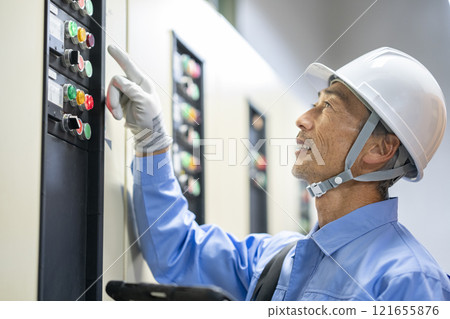 Building maintenance staff image: Profile of a worker inspecting electrical equipment Building maintenance staff image: Profile of a worker inspecting electrical equipment 121655876