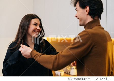 Joyful interaction between a couple in a modern kitchen setting Joyful interaction between a couple in a modern kitchen setting 121656190