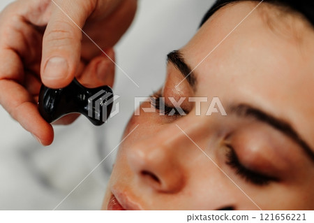 Beauty treatment session focusing on facial massage in a serene spa environment 121656221