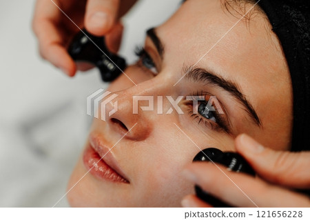 Beauty treatment involving facial massage and relaxation in a spa setting 121656228