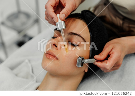 Beauty treatment session at a spa featuring facial microneedling and serum application Beauty treatment session at a spa featuring facial microneedling and serum application 121656242