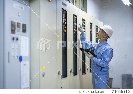 Building maintenance staff image: Profile of a worker inspecting electrical equipment 121656510