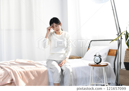 Young Asian woman suffering from headache in bed Young Asian woman suffering from headache in bed 121657099