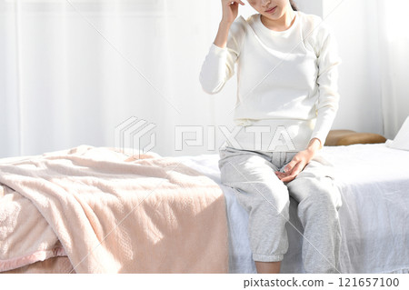 Young Asian woman suffering from headache in bed Young Asian woman suffering from headache in bed 121657100