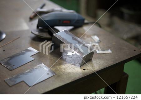 Deburring work being done with a grinder 121657224