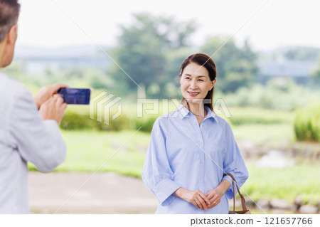 Smiling senior couple taking a photo Smiling senior couple taking a photo 121657766