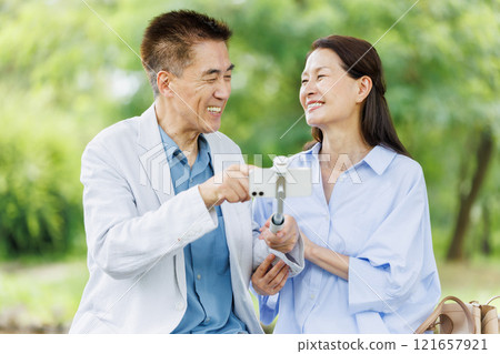 年長的夫婦,與智能手機拍照 年長的夫婦,與智能手機拍照 121657921