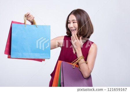 Shopping Asian woman with short hairs smile wearing red dress Holding Shopping bags,Cheerful and Happiness enjoy shopping in black friday sale,Isolated on gray background 121659167