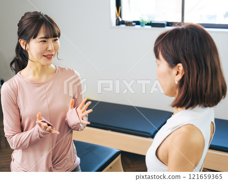 一位女士在健身房接受教練的諮詢 121659365