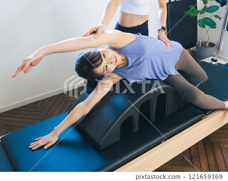 一位女士正在上機器普拉提課 一位女士正在上機器普拉提課 121659369