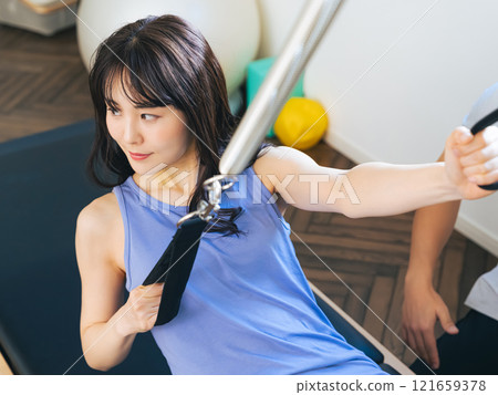 A woman taking a machine pilates lesson 121659378