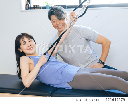 A woman taking a machine pilates lesson A woman taking a machine pilates lesson 121659379