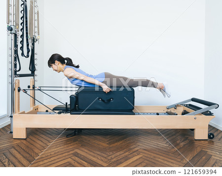 Woman doing machine pilates training 121659394