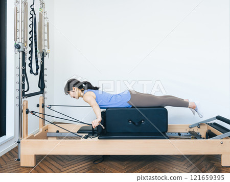 Woman doing machine pilates training 121659395