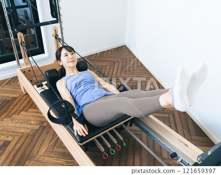 Woman doing machine pilates training 121659397
