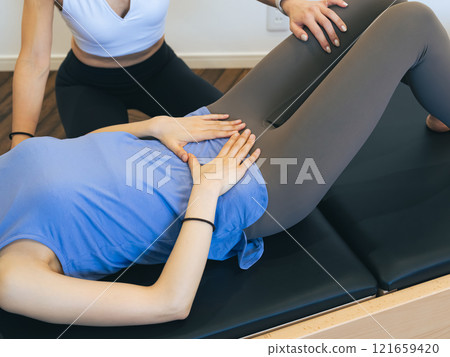 Woman taking pilates class 121659420