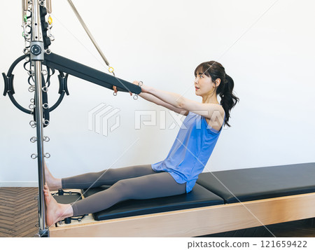 Woman doing machine pilates training 121659422
