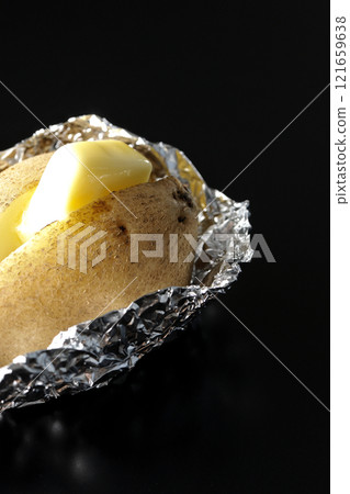 Photographing buttered potatoes on a black background Photographing buttered potatoes on a black background 121659638