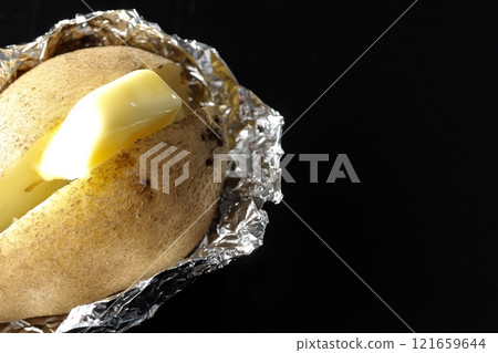 Photographing buttered potatoes on a black background Photographing buttered potatoes on a black background 121659644