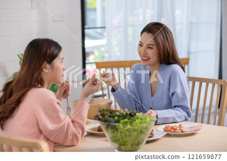 Couple LGBTQ lover cooking in kitchen together smile and laughing. Happiness and tender moment quality time at home. LGBTQ+ Concept Couple LGBTQ lover cooking in kitchen together smile and laughing. Happiness and tender moment quality time at home. LGBTQ+ Concept 121659877