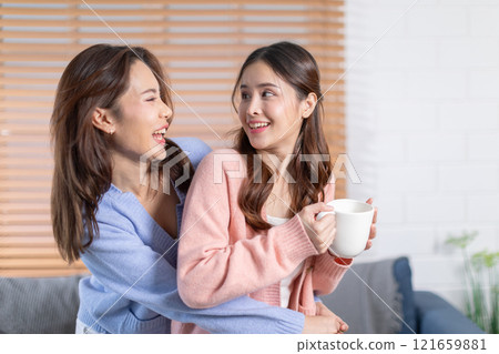 Beautiful two Asian female LGBT lesbian embracing with love and romance , Positive mood and good moment with quality time at warmth place.LGBTQ+ Lifestyle Pride Month 121659881