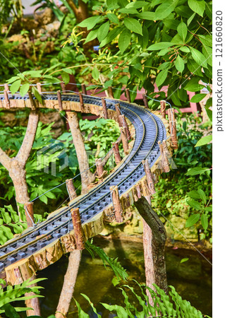 Miniature Train Track in Lush Garden Setting Eye Level View Miniature Train Track in Lush Garden Setting Eye Level View 121660820