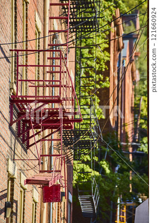 Urban Fire Escapes and Brick Facade in Golden Hour Perspective 121660924