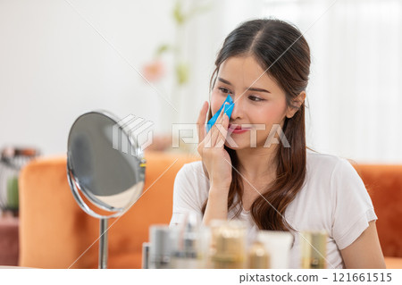 Woman Using Oil-Absorbing Film for Skincare in Bright Room Woman Using Oil-Absorbing Film for Skincare in Bright Room 121661515