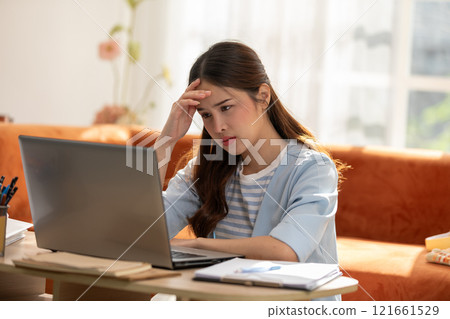 Asian Woman Experiencing Stress While Working on Laptop at Home Asian Woman Experiencing Stress While Working on Laptop at Home 121661529