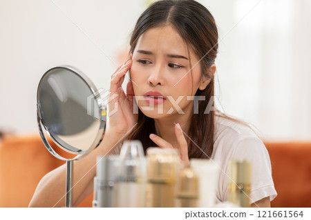 Asian young woman looking in mirror worry about pores facial skin problem with acne and dry skin,Skin care concept 121661564