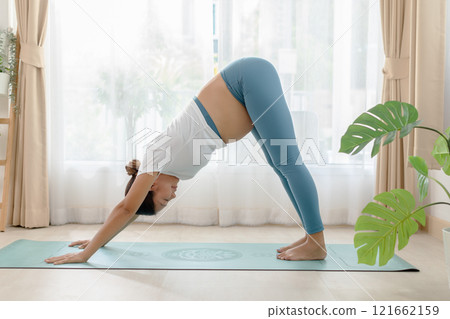 Pregnant woman practicing yoga at home 121662159